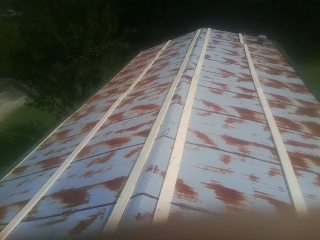 Rusted metal roof panels with new wood purlins before replacement — Storm Damage Roof Repair in Manorville by Roofing Brothers
