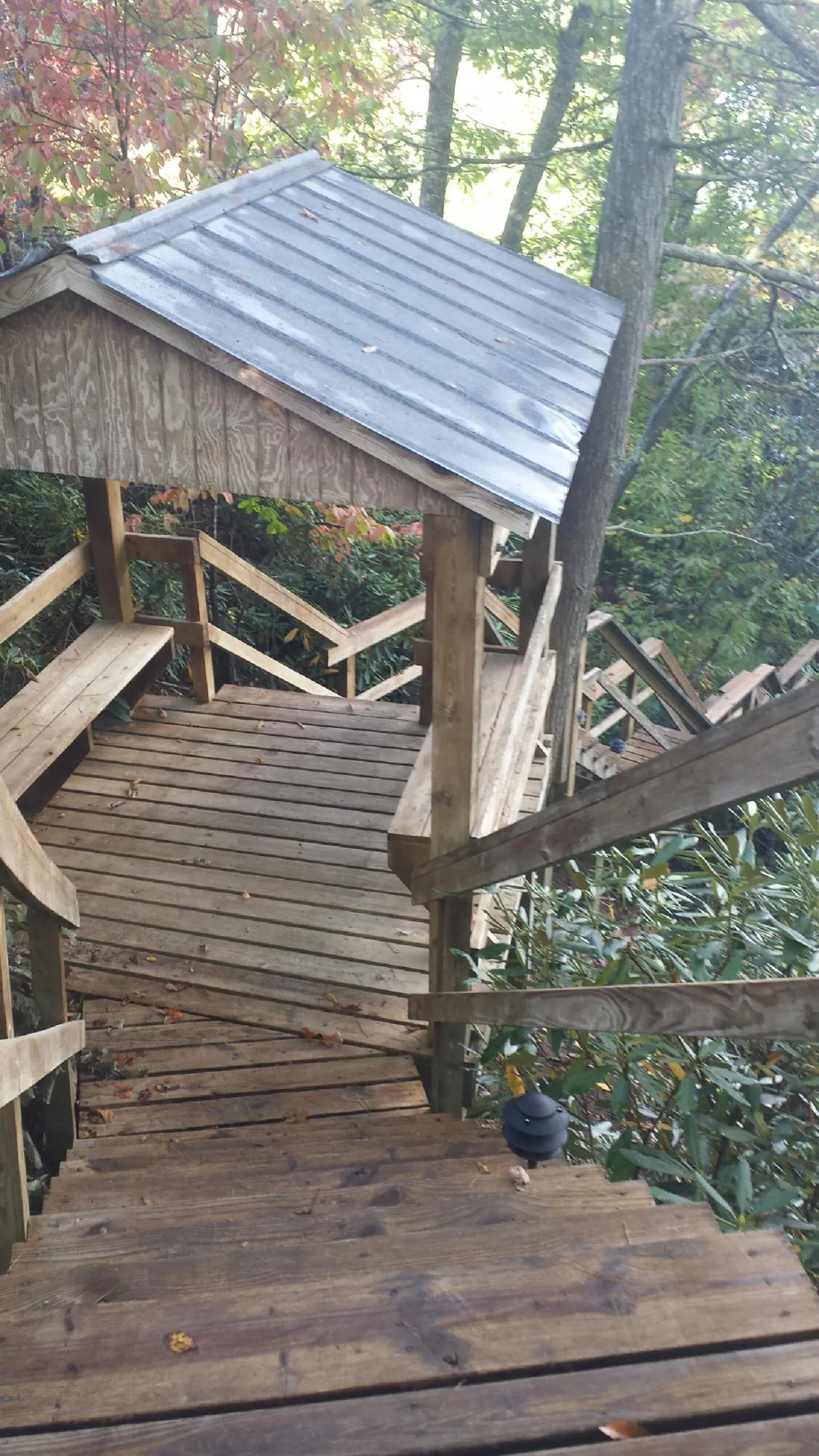 Metal roofed shelter over wooden steps on a wooded walkway — Skylight Repair & Installation work by our crew in Manorville